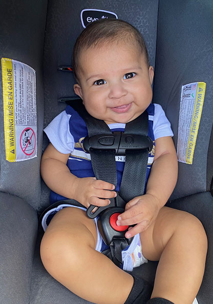 Baby Michael smiling in his car seaat