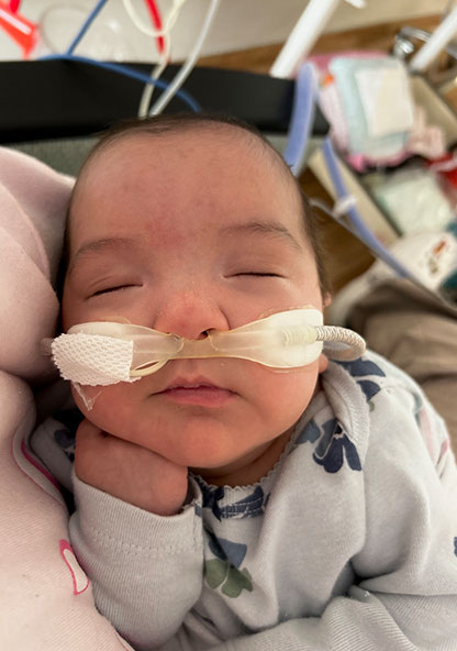 Baby Novalynn is sleeping in her mother's arms while at the NICU at CHRISTUS Children's