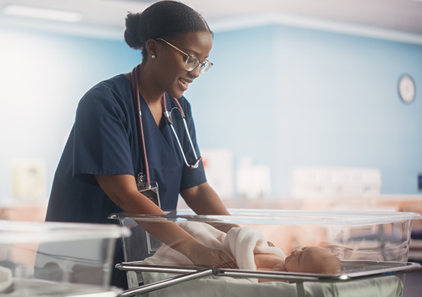 A pediatrician checks on a baby in the nursery