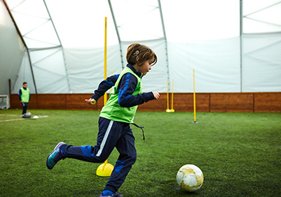 Adolescent boy with cochlear implant playing soccer
