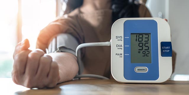 Woman taking blood pressure using blood pressure machine