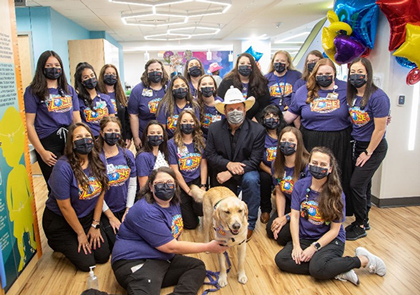 The Child Life Team surrounding singer Garth Brooks at the Child Life Zone at CHRISTUS Children's